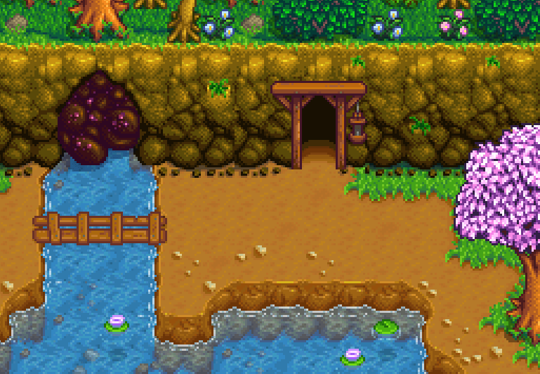 Entrada das minas do Stardew Valley na encosta da Montanha, ao lado de um riacho com ponte de madeira