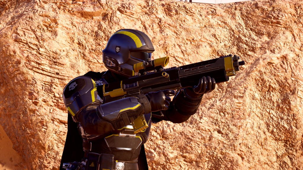 Helldiver de armadura preta e amarela mira o rifle de presente do Liberty Day de Helldivers 2 diante de uma rocha alaranjada